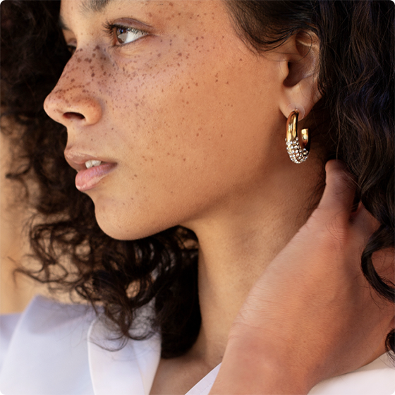 Model wearing gold and diamond earrings